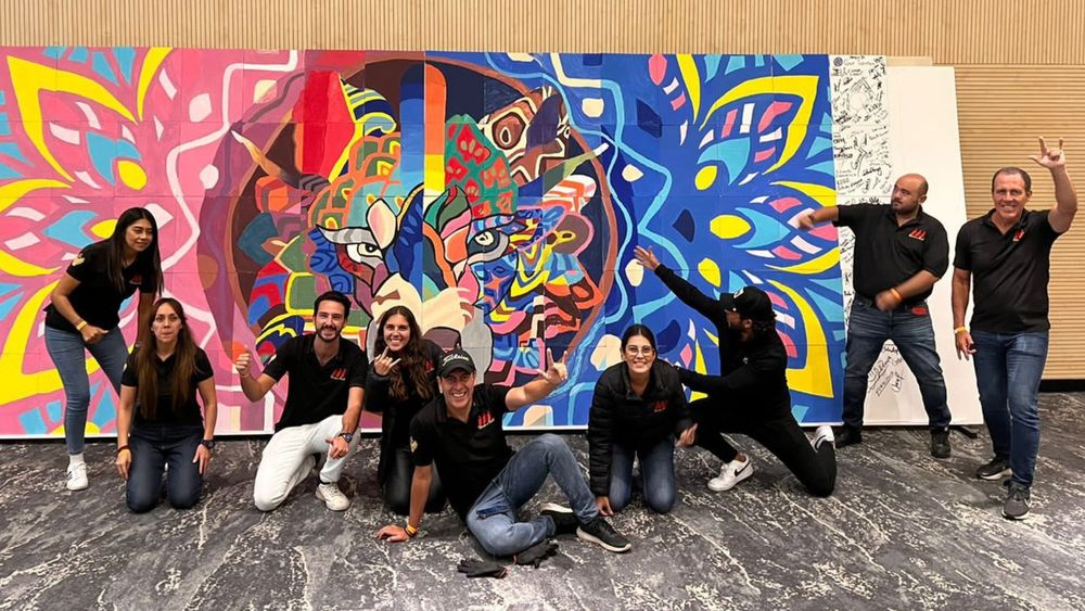 Equipo frente a un mural de colores